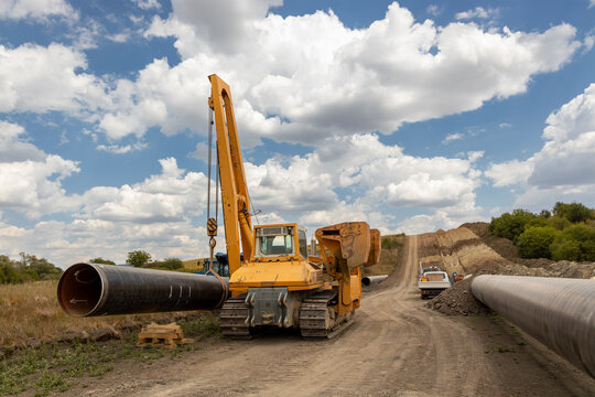 Large Pipeline Construction. Heavy Machinery Installing Underground Gas or Oil Pipeline. Infrastructure Development and Energy Industry Concept.  Industrial Infrastructure Project