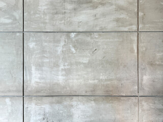 Close up of decorative grey cement concrete wall  in rectangular tiles and grouts. Concrete wall is often used for industrial and raw material suitable for building. Seamless background texture.