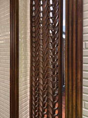 White subway tiles wall with leaves shape screen divider partition and fluted wood panel. Interior...