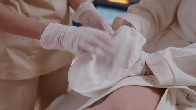 Hand paraffin therapy with cream and wrap before thermal treatment