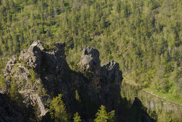 A rocky cliff in the valley of a mountain river.
