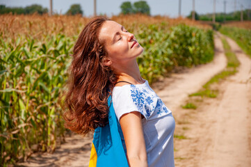 Naklejka premium Flag of Ukraine. National flag patriotic girl. Independence day. Patriotic symbol. Patriotism. Ukrainian flag memorial day or 24th of August. Girl holding Ukrainian flag in field. Embroidery day