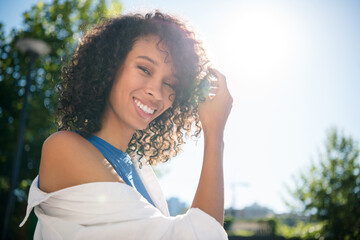 Young woman enjoying a sunny day outdoors in a stylish casual fashion with a lovely smile