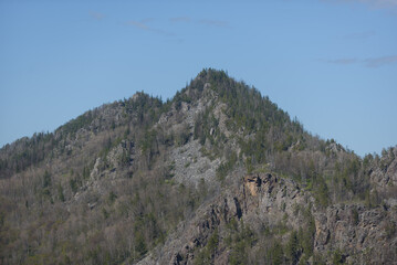 A majestic pointed mountain covered with forest.