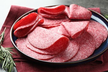 Slices of delicious sausage served on grey table, closeup