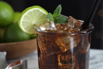 Tasty Cuba Libre cocktail in glass on table, closeup