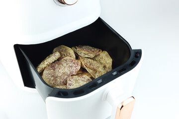 delicious homemade organic taro are cooked by using a white air fryer or oil free fryer appliance for being lunch in afternoon with family members for Christmas new year party snacks