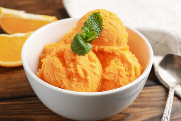 Tasty orange sorbet, fresh fruits and mint on wooden table, closeup