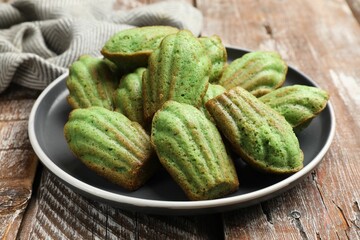 Tasty matcha madeleine cakes on wooden table, closeup
