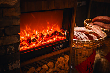 Warmly lit traditional Chinese shop street at night in Wangxian Valley Town, featuring wooden buildings, lanterns, and a cozy atmosphere under a large tree.