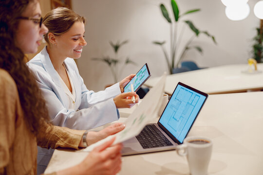 Women participating in a collaborative working session with modern technology at a stylish office table setup