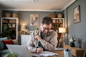 Architect working from home drawing blueprint plans on paper