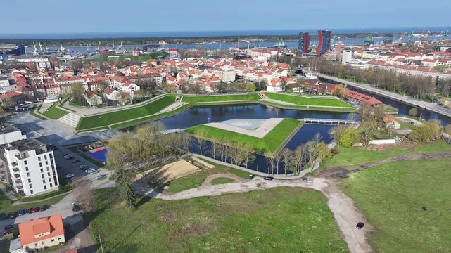 Aerial drone view of Jonas Hill (Jono kalnelis) in Klaipėda, Lithuania, captured during summer 2024 with the Klaipėda port and urban landscape in the background on a bright, sunny day.