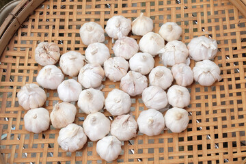 Fresh Garlic on a woven bamboo tray ,Drying on the sun.