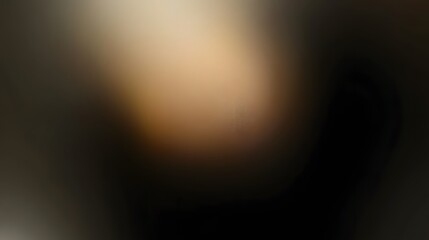 Blurry, out-of-focus image featuring a gradient of dark and light brown and beige tones transitioning into a dark background. The colors are soft and blended together.