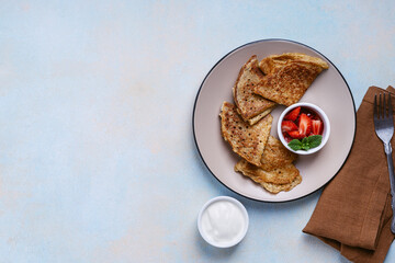 Sweet rye and whole grain crepes with strawberry and sour cream directly above