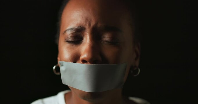 Face, stress and black woman with tape in studio on dark background for gender equality or domestic violence. Portrait, silence or abuse of scared female victim with mouth covered for censored voice