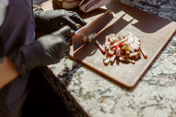 An exceptionally skilled chef meticulously chops vibrant and colorful vegetables on a sleek wooden cutting board