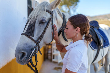 Woman gently petting chestnut horse, highlighting deep connection between rider and equine companion