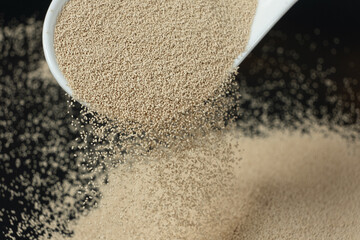 Dry yeast is poured out of a spoon