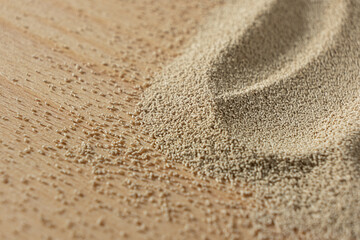 Dry yeast scattered on wooden surface, copy place for text.