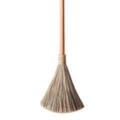 A broom with a wooden handle and straw bristles isolated against a black background in a studio shot