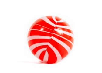 Red and white striped plastic ball, children's toy, isolated on white background
