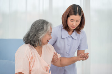 Obraz premium Smiling caring Asian doctor supporting holding hand of olde senior female patient at clinic or hospital