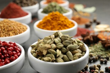 Different aromatic spices on grey table, closeup
