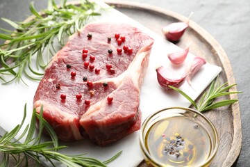Piece of raw beef meat and spices on table, closeup