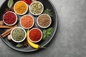 Different aromatic spices on grey table, top view. Space for text