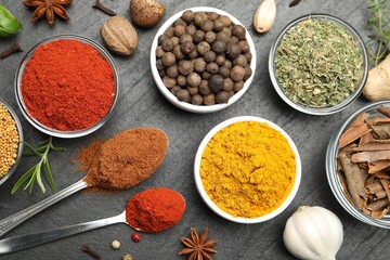 Different aromatic spices on black table, flat lay
