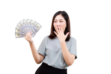A woman holds a fan of US dollar bills while covering her mouth in surprise.