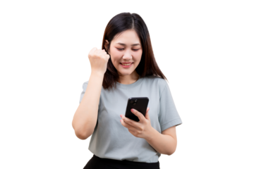 A young woman smiles while looking at her smartphone and making a fist pump gesture of excitement.