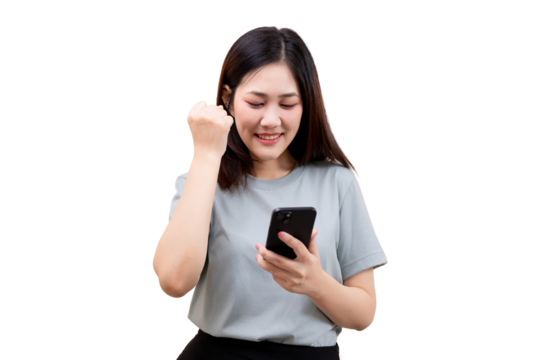 A young woman smiles while looking at her smartphone and making a fist pump gesture of excitement.