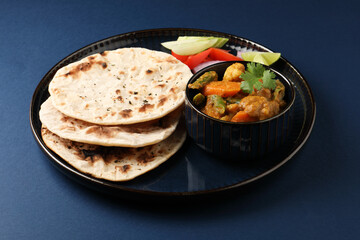 Mix veg Kolhapuri, a spicy mixed vegetable curry served with roti and chopped salad
