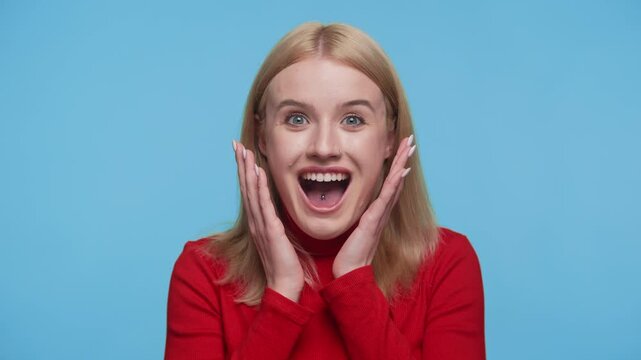 Excited woman with surprised face expression on blue