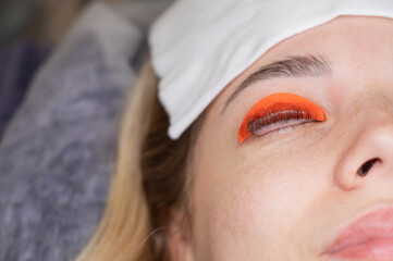Caucasian woman undergoing eyelash lamination procedure. 