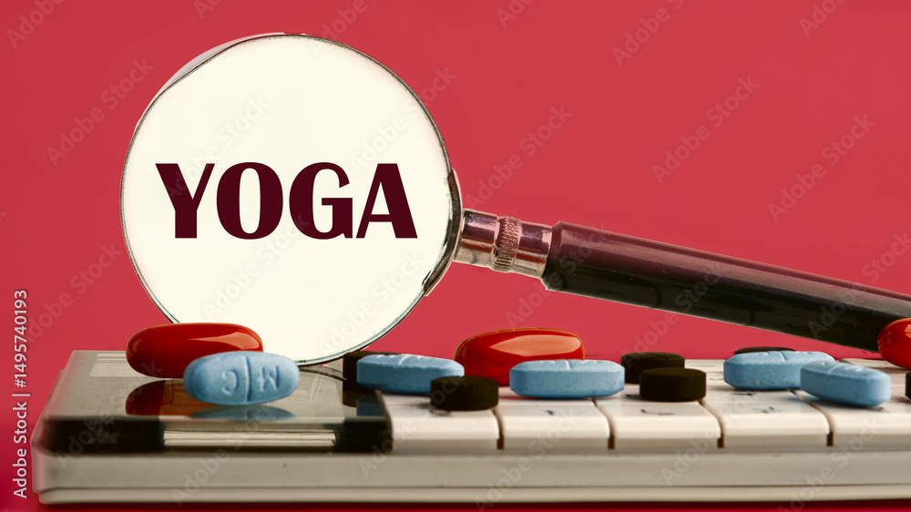 Fototapete the word yoga written through a magnifying glass on a calculator with pills on it on a red backgroun