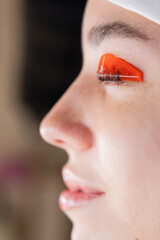 Caucasian woman undergoing eyelash lamination procedure. 