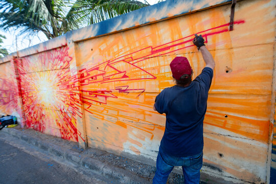 un artiste r&eacute;alise une peinture murale sur un mur le long de l'autoroute qui m&egrave;ne au centre de Dakar au S&eacute;n&eacute;gal en Afrique de l'Ouest.