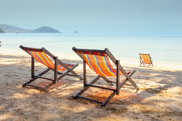sun beach chairs on shore near sea.