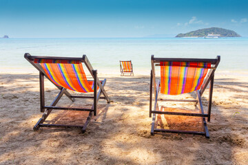 sun beach chairs on shore near sea.