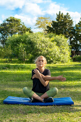 Woman doing stretching exercises in sunny park