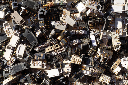 Mobile phone charging connectors are removed from old phones and are collected for recycling and extraction of precious metals from electronic waste. concept electronic waste valuable