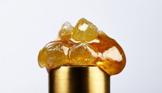 saucey live resin diamonds on a gold titanium dab tool with a white background