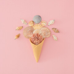 Creative summer flat lay with shells in a waffle cone on a clean pastel background..Ideal for beach-themed ads, tropical designs or editorial visual storytelling...