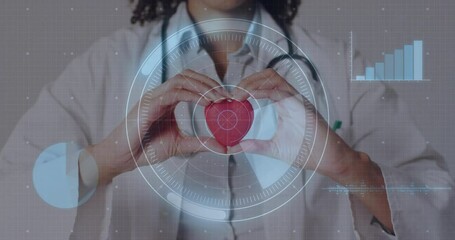 Doctor bringing heart model center, grid, rings rotating around heart, code and bar chart rising - Powered by Adobe