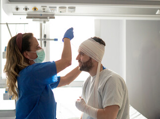 Nurse changing bandages of patient recovering in hospital bed