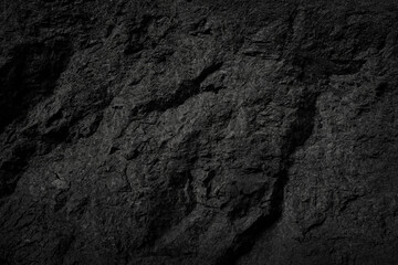 Empty black stone wall on cave surface for abstract background and texture. Template for design, natural patterns, space for work, banner,seamless wallpaper, close up.